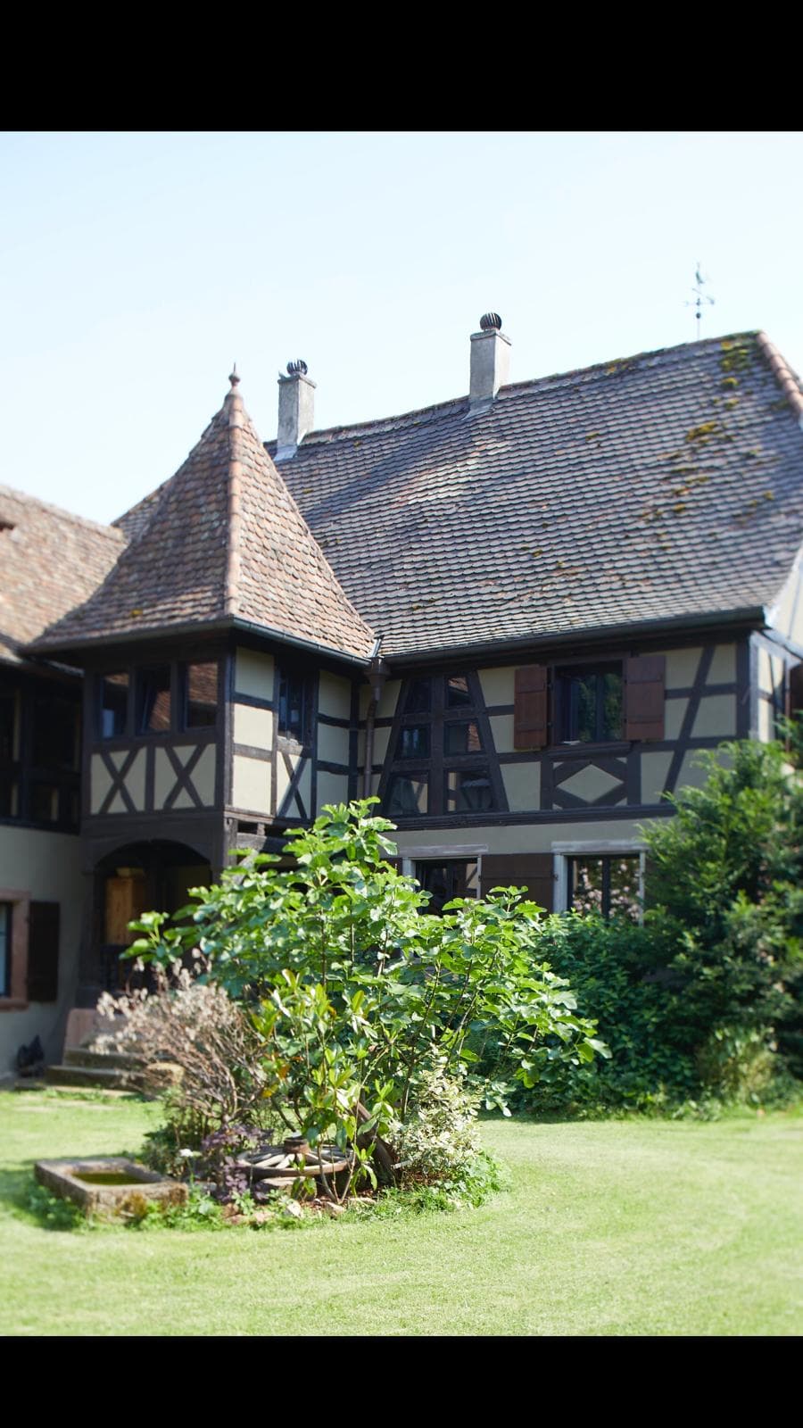 Façade de maison alsacienne à colombages restaurée avec toiture en tuiles plates