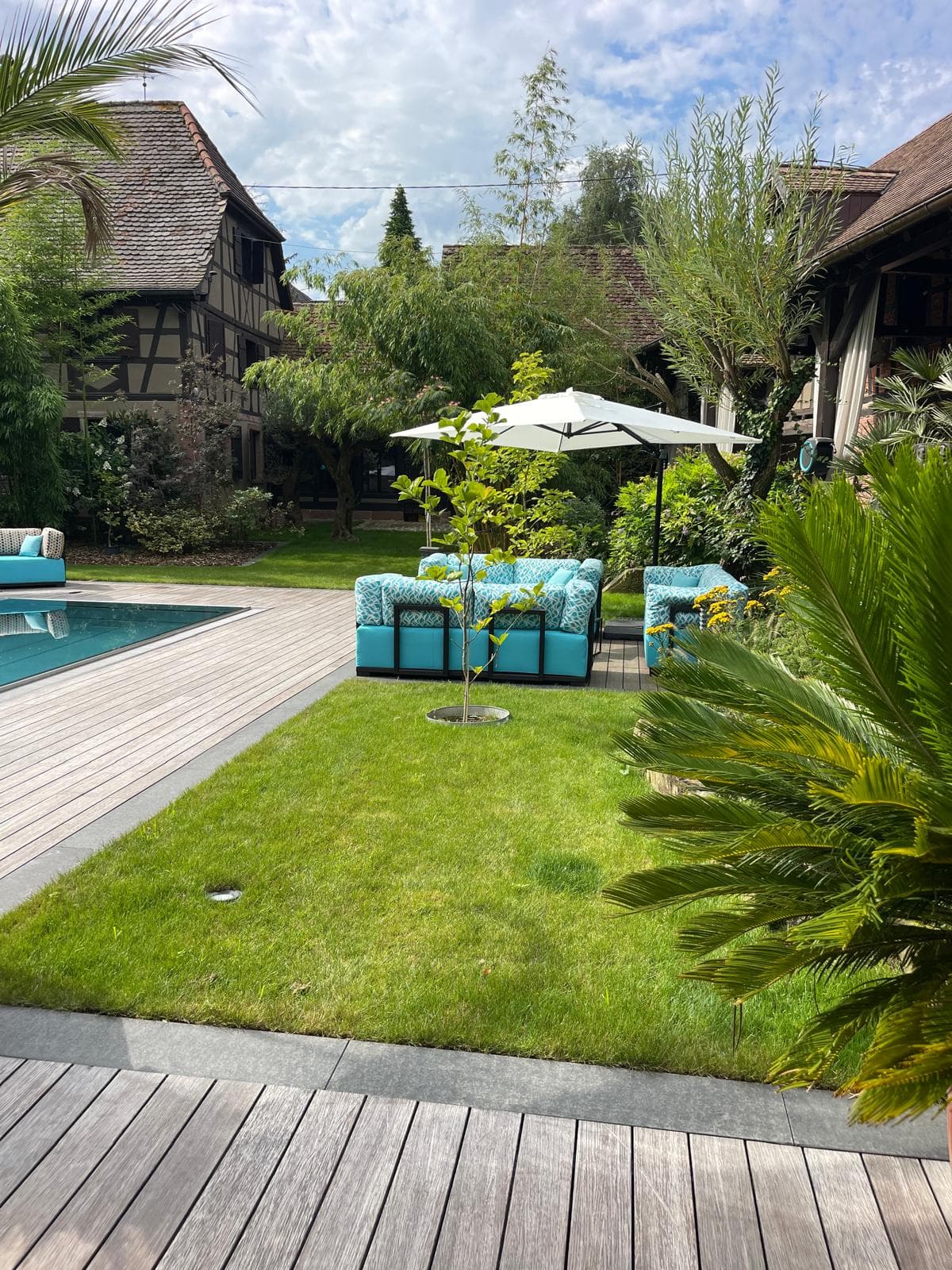 Piscine moderne avec canapés outdoor turquoise et terrasse bois