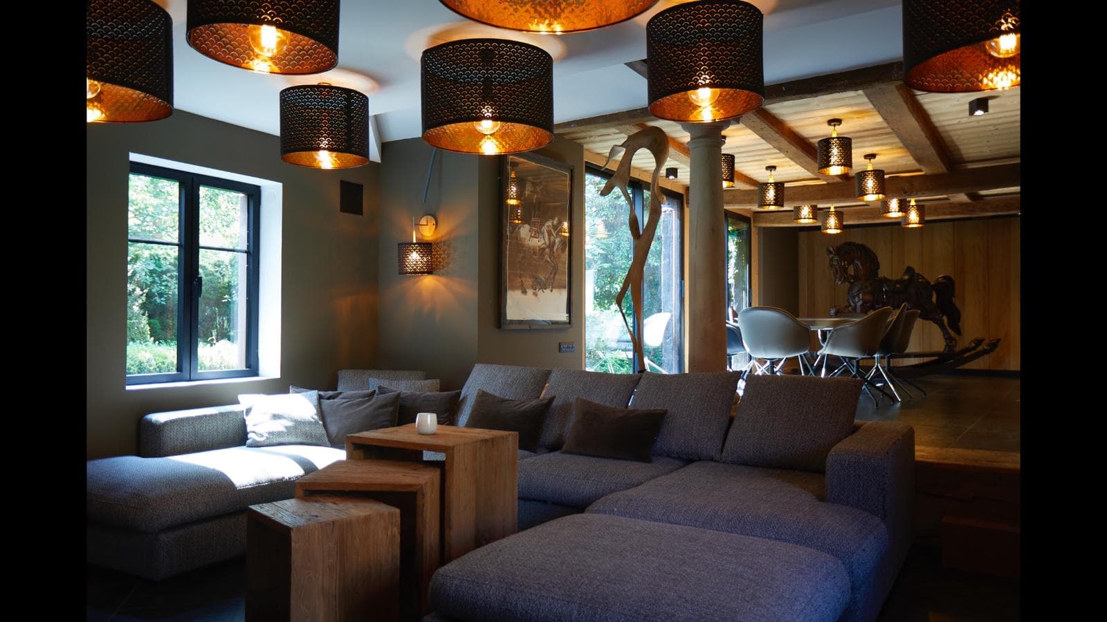 Salon contemporain avec lustres pendants et cheminée allumée