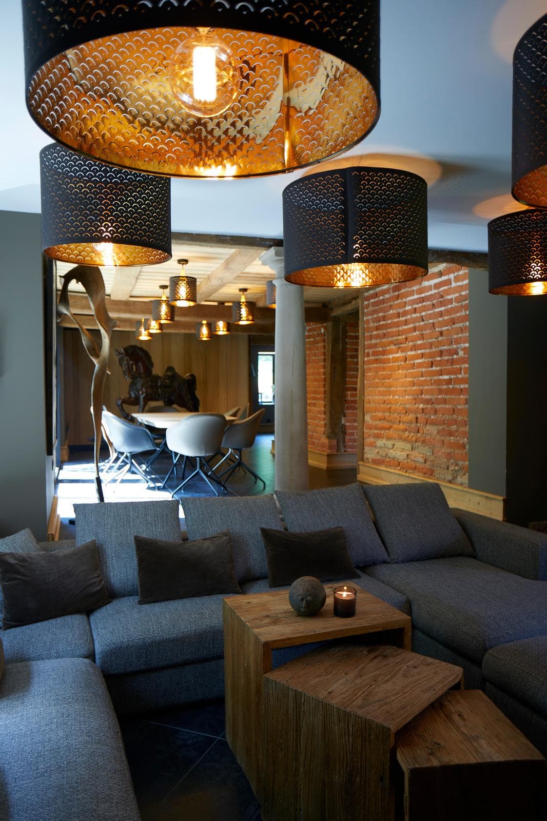 Salon contemporain avec grande suspension noire et canapé d'angle