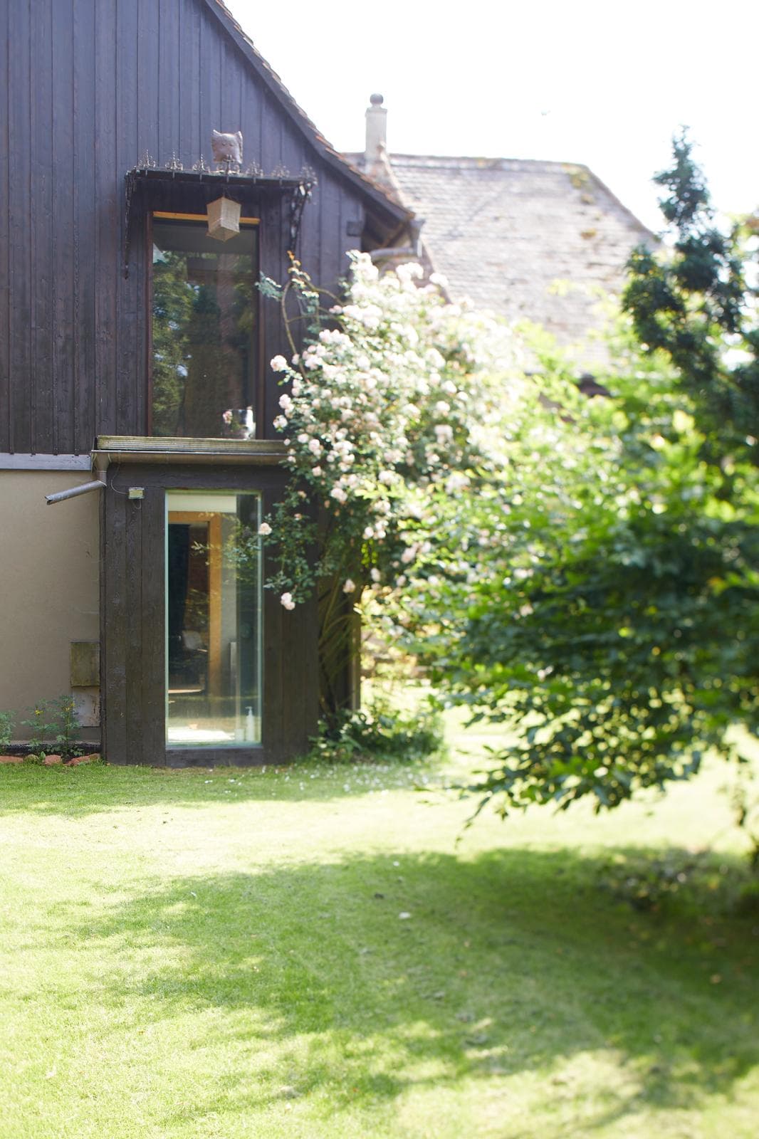 Extension contemporaine en verre et bois sur maison existante